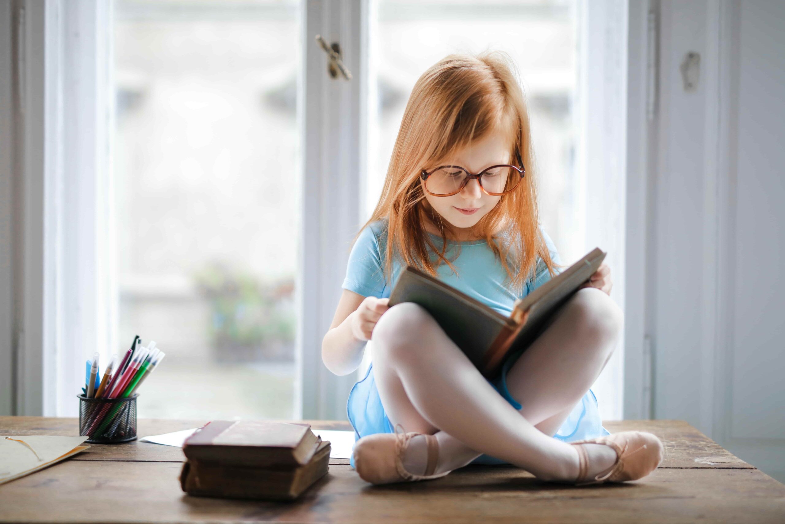 Little girl reading with legs crossed