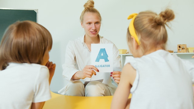 Teacher with kids showing flashcard reading