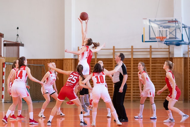 Team of women in red uniforms playing basketball