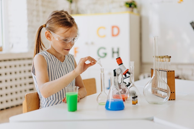 Little girl with pigtails doing a science experiment