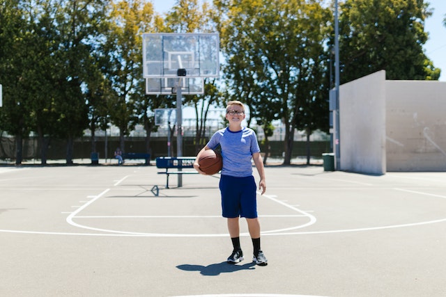 Little boy holding basketball outside