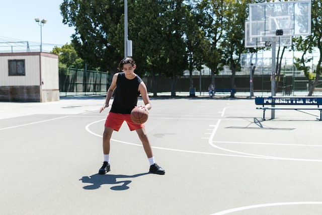 Teen playing basketball outside