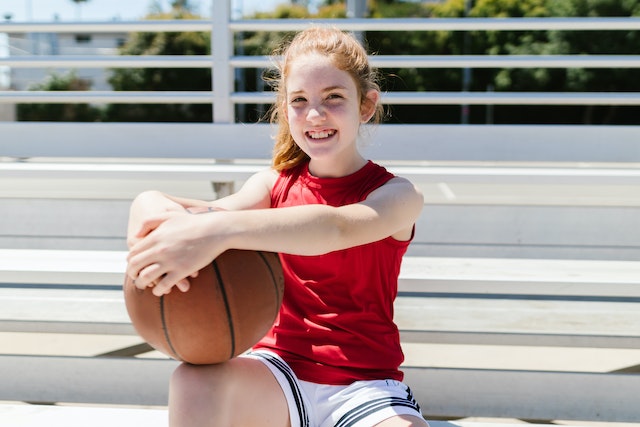 Girl sitting holding a basketball